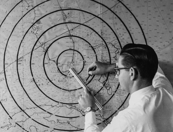 Student plots points on large map in radar laboratory